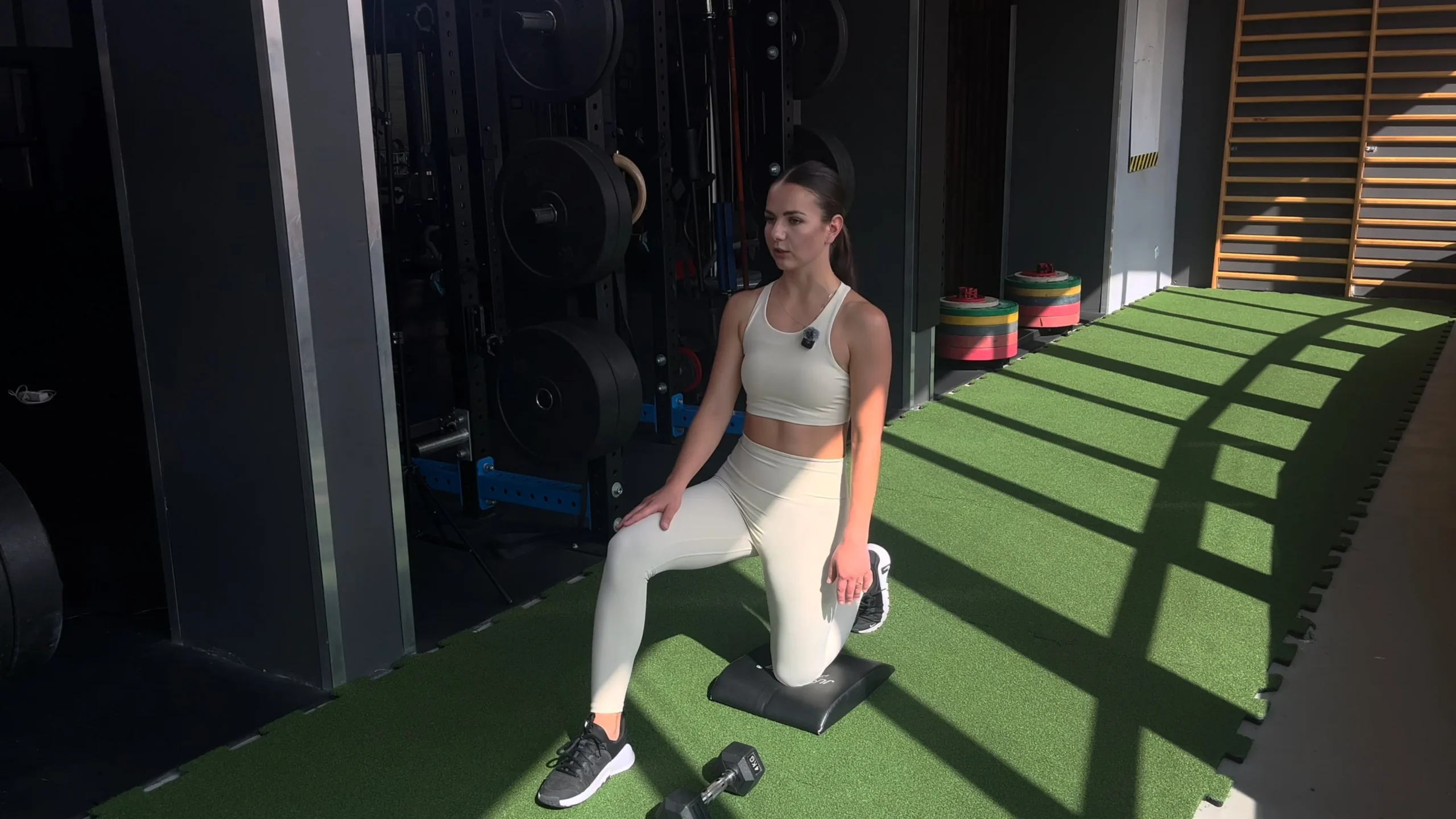 Wyciskanie hantla nad głowę w klęku jednonóż chwytem nautralnym ręką przeciwną do nogi