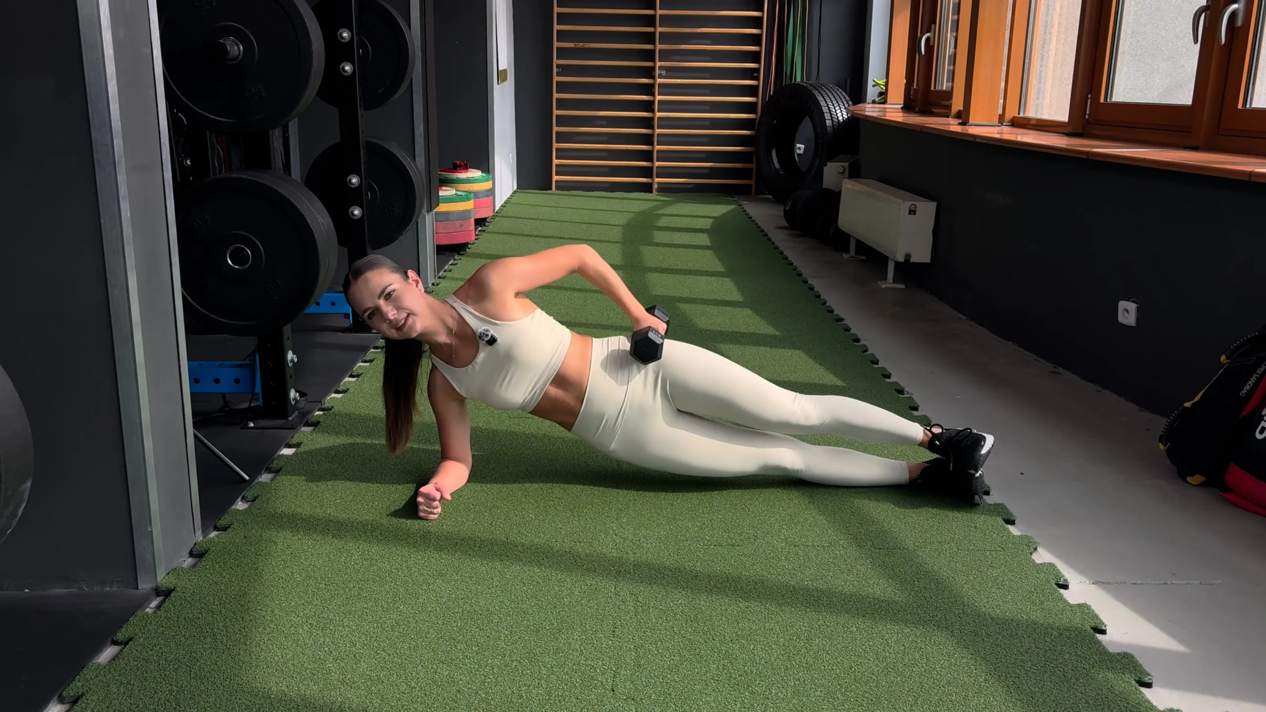 Wznosy bioder w desce bokiem z hantlem na biodrze